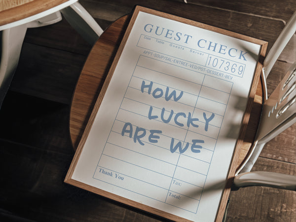 close up view how lucky are we quote on blue retro guest check wall art 