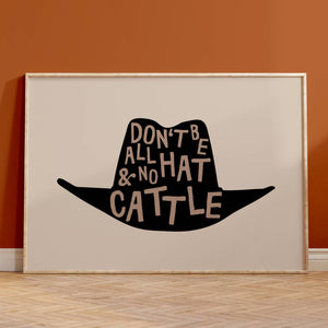 beige background with black cowboy hat, brown lettering inside hat that says don't be all hat and no cattle