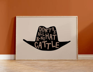 beige background with black cowboy hat, brown lettering inside hat that says don't be all hat and no cattle