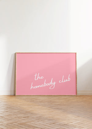 light pink background with white script typography the homebody club horizontal wall art