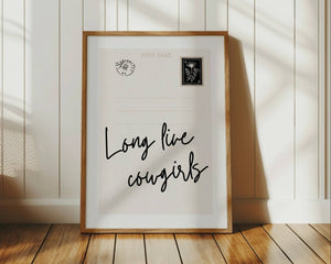 long live cowgirls quote in black on vertical postcard print with vintage floral stamp