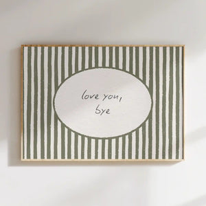 A rectangular framed wall art print with vertical olive green and white stripes, featuring a white oval center with the handwritten text 'love you, bye'. The print is mounted on a white wall with soft diagonal shadows.