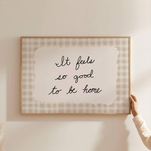 hand drawn script font with "it feels so good to be home" quote on beige gingham poster horizontal orientation wall art