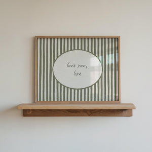 love you bye quote in hand drawn script typography on olive green striped wall art with oval cutout, horizontal wall art