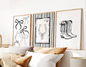Bedroom with framed artwork on the wall, including illustrations of bows, a horseshoe, and boots.