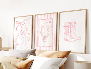 Bedroom with framed pink line art on the wall, featuring a bow, horseshoe, and boots.